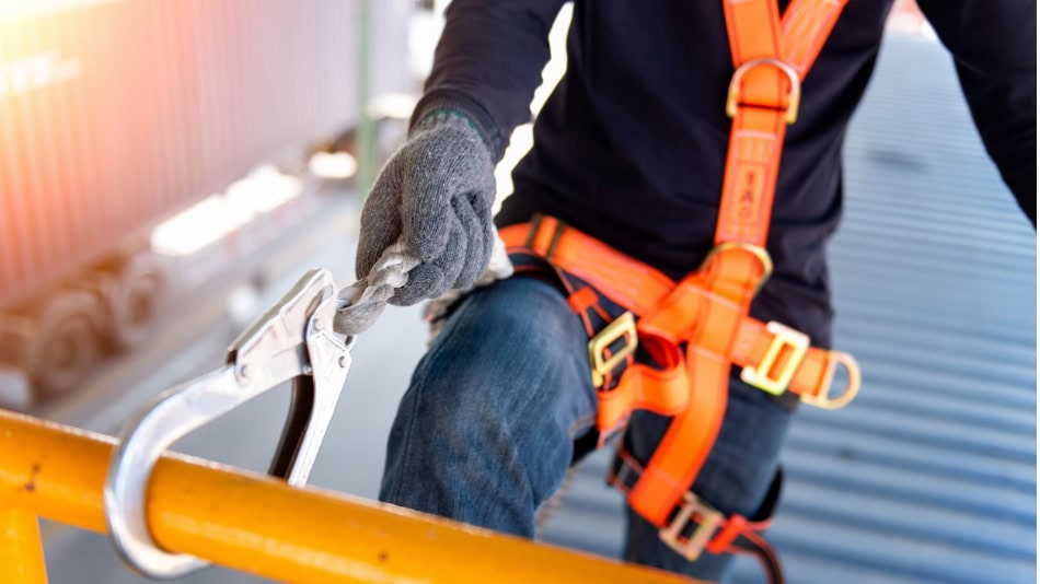 Trabajador de la construcción utilizando arnés de seguridad diferencia entre riesgo y peligro