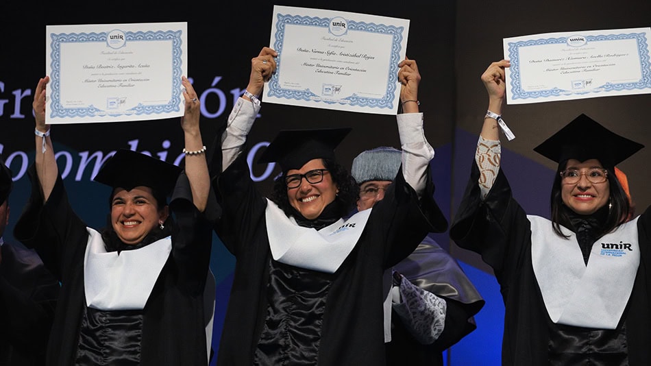 Estudiantes de la Facultad de Educación en la ceremonia de la tarde del viernes, muestras orgullosas sus diplomas simbólicos.