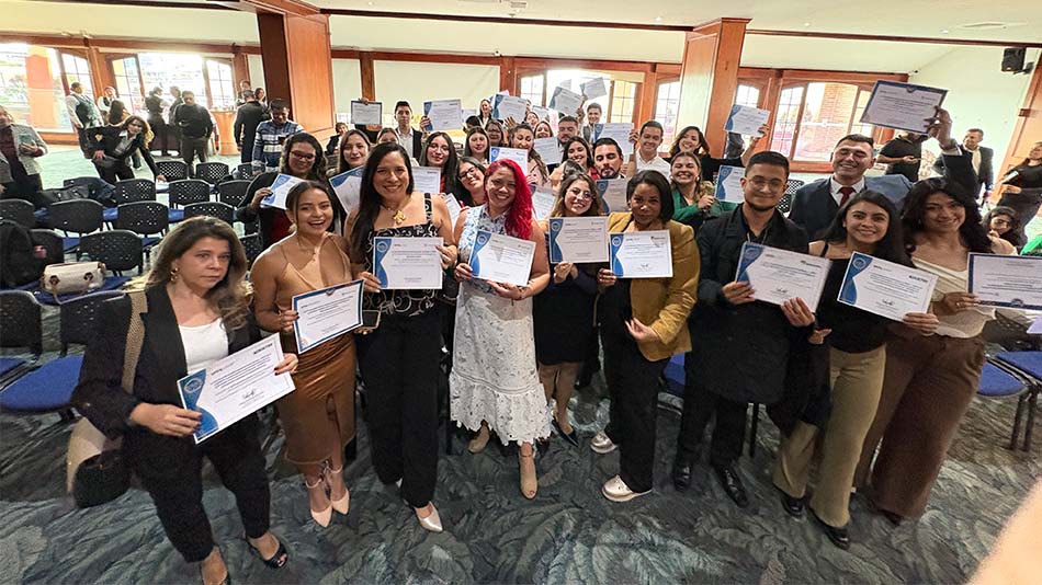 Beneficiarios con una beca muestras su satisfacci&oacute;n al final del acto.